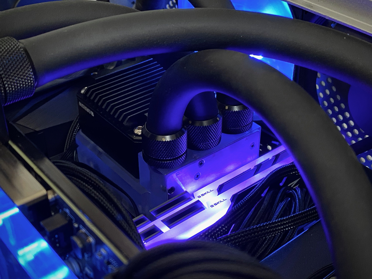 Close up picture of the pump block in the running computer. Blue and purple lights glowing around it.