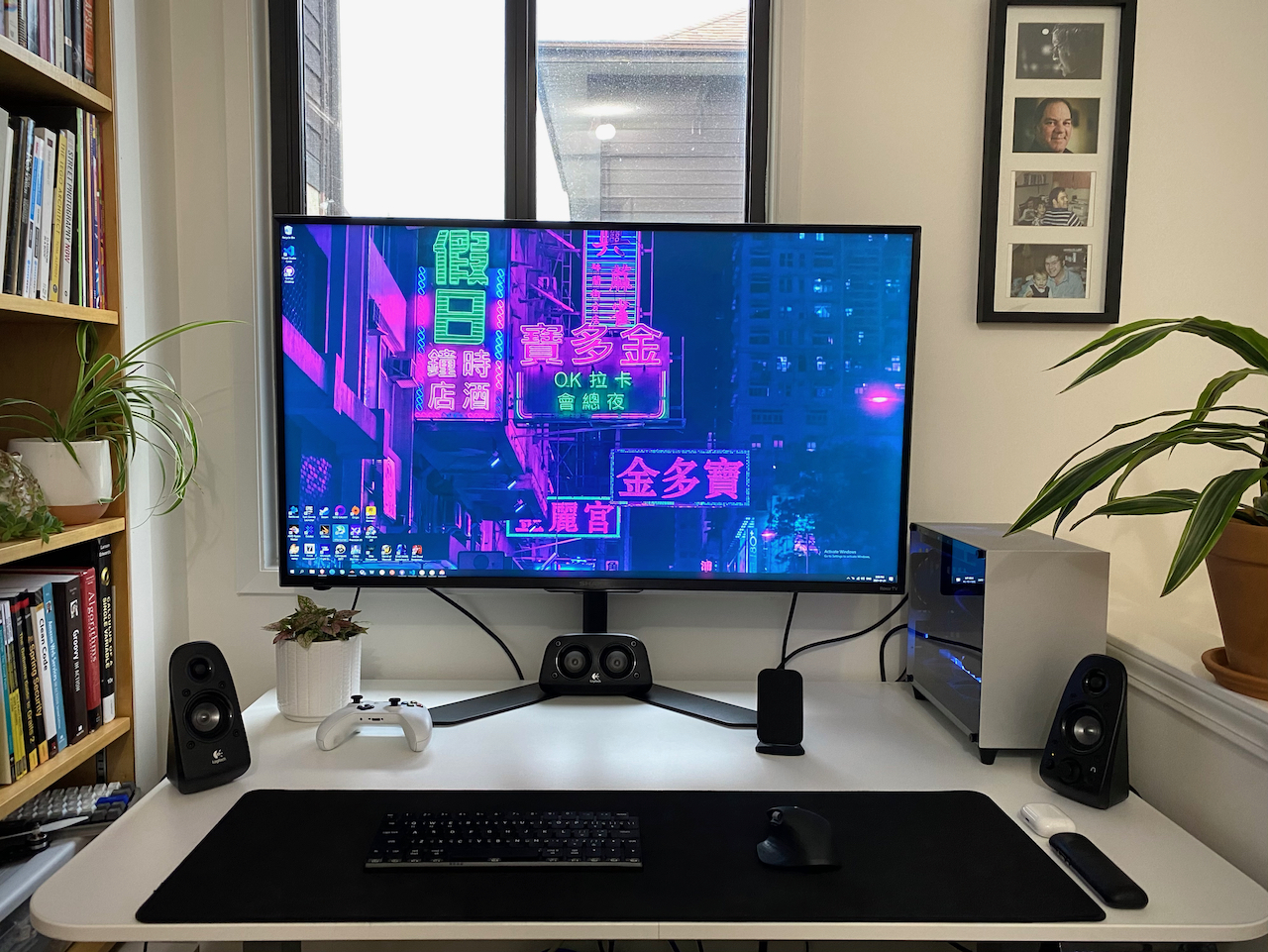 Wide picture of entire desk showing my monitor, pc, keyboard, mouse, and speakers. There is a window behind the monitor and plants on either side.